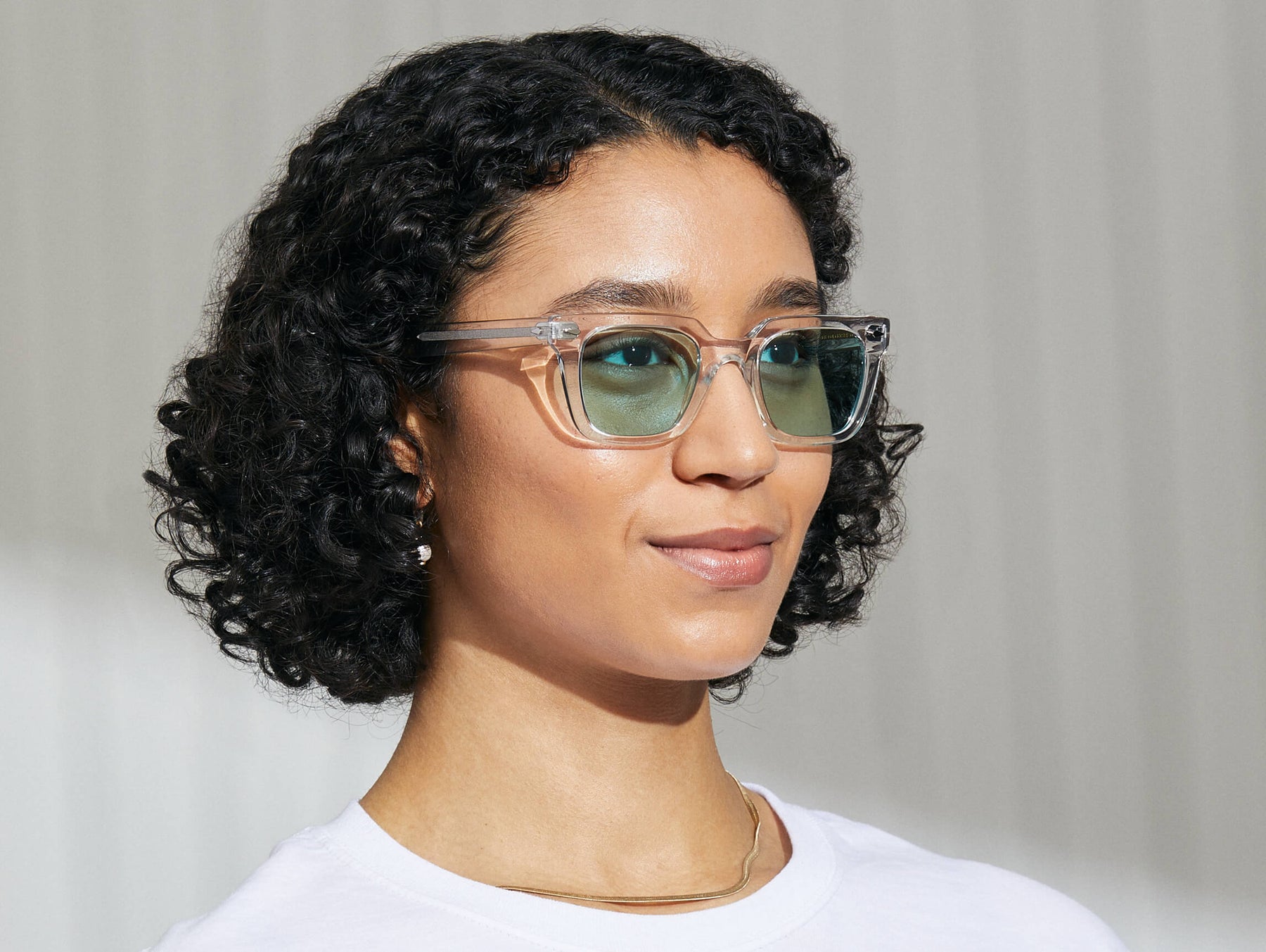 Model is wearing The GROBER in Crystal in size 48 with Turquoise Tinted Lenses Model is wearing The GROBER in Crystal in size 48 with Turquoise Tinted Lenses