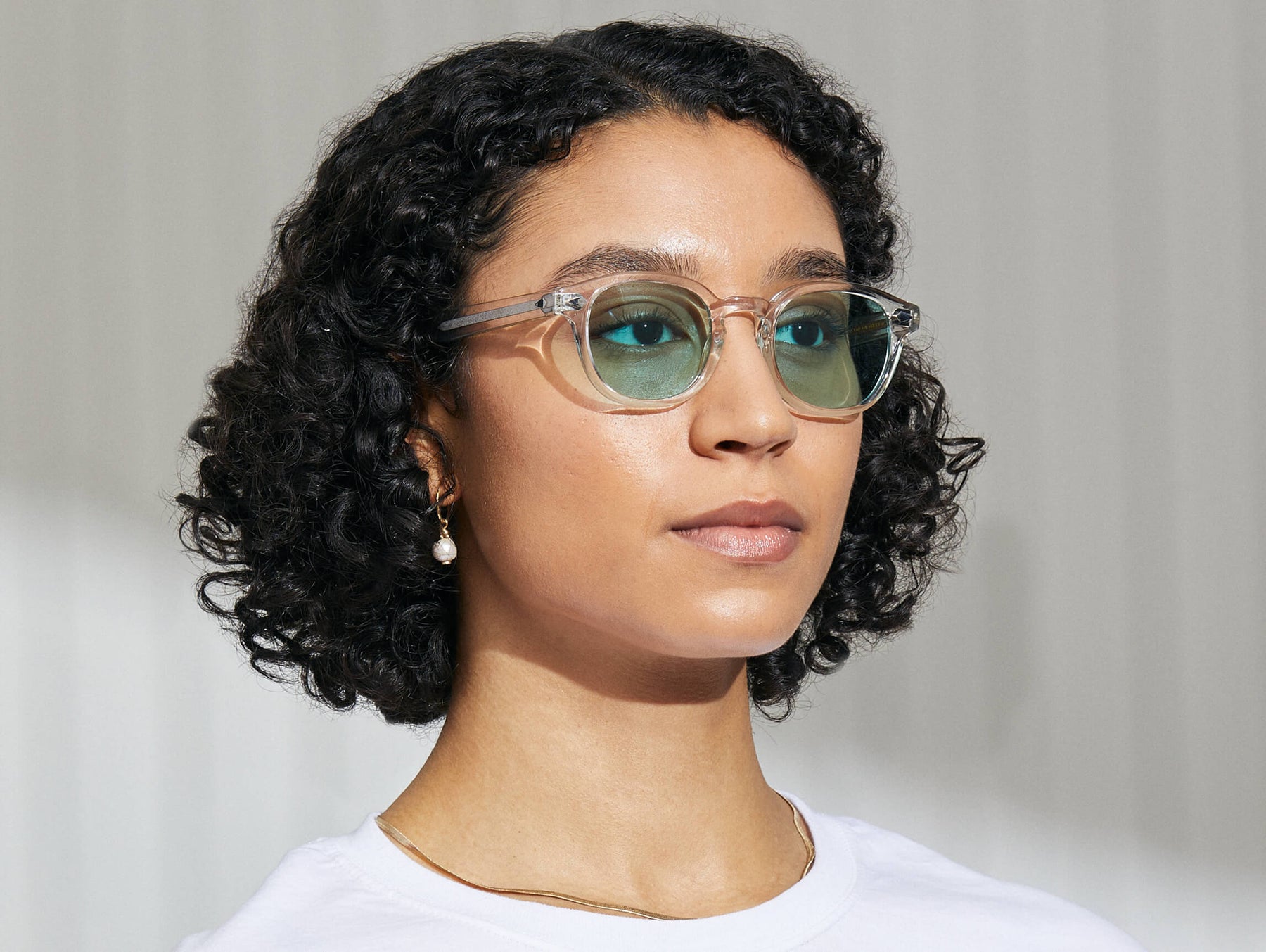 Model is wearing The LEMTOSH in Crystal in size 49 with Turquoise Tinted Lenses Model is wearing The LEMTOSH in Crystal in size 49 with Turquoise Tinted Lenses