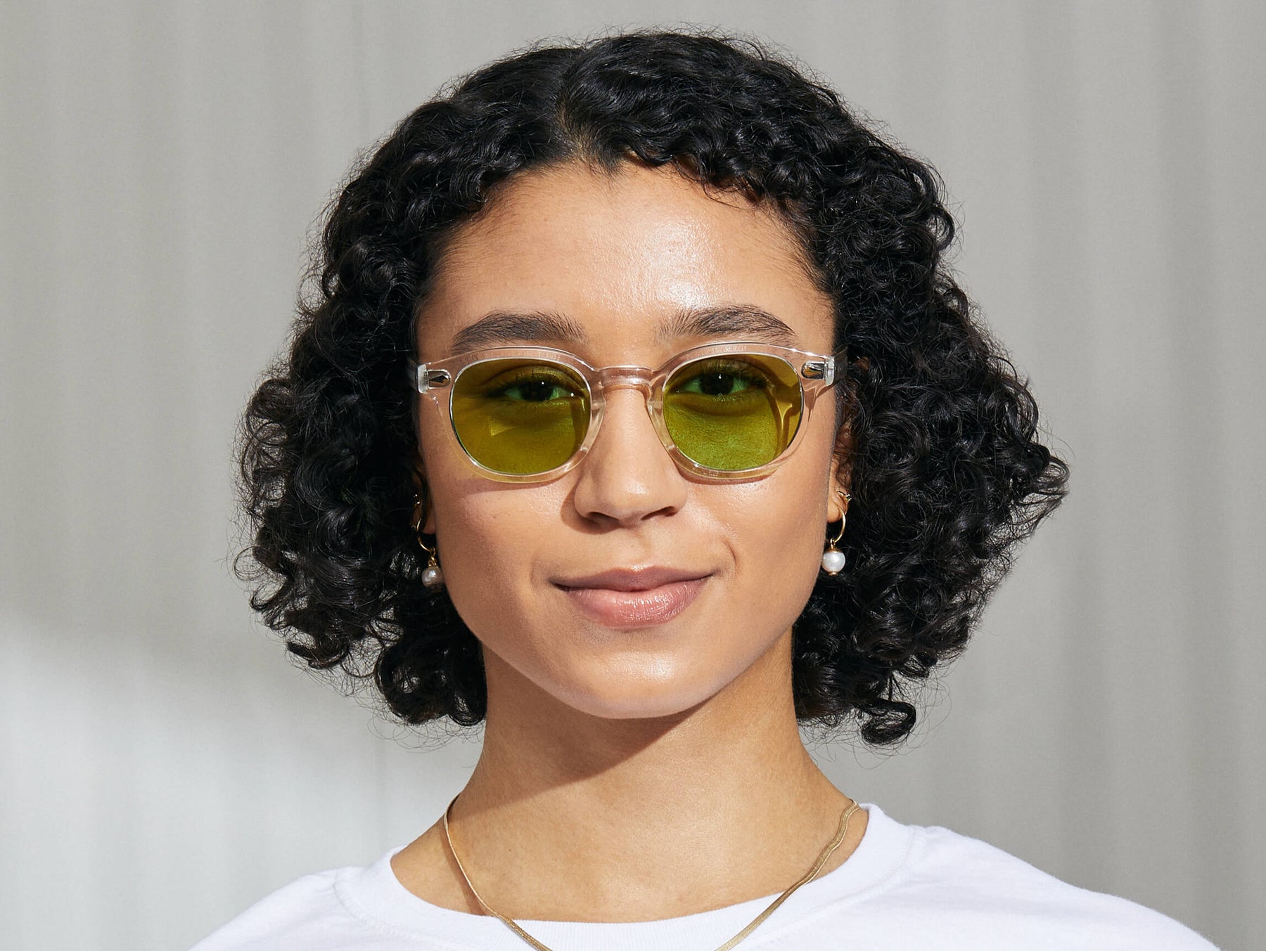 Model is wearing The LEMTOSH in Crystal in size 49 with Garnet Green Tinted Lenses Model is wearing The LEMTOSH in Crystal in size 49 with Garnet Green Tinted Lenses