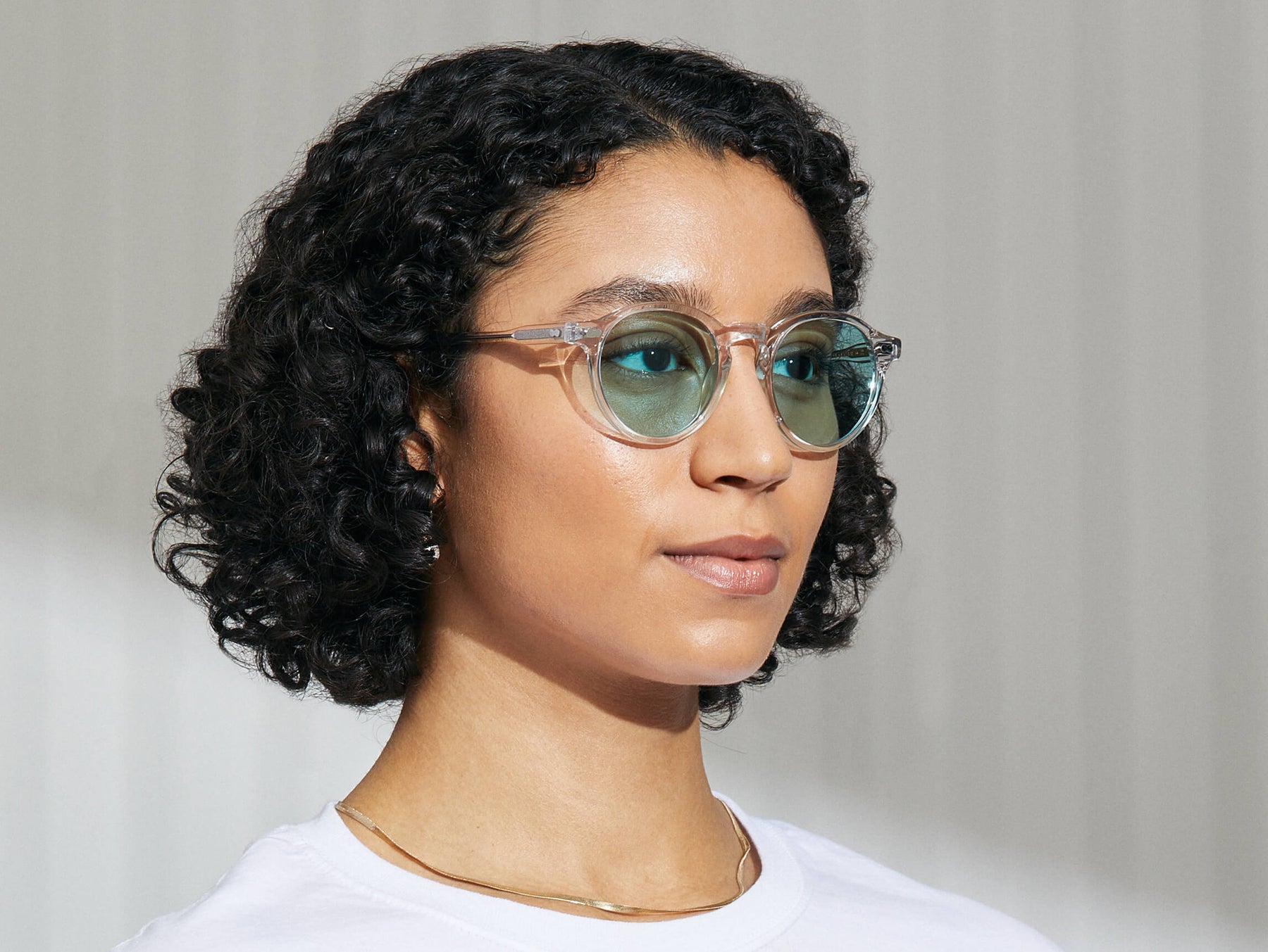 Model is wearing The MILTZEN in Crystal in size 49 with Turquoise Tinted Lenses Model is wearing The MILTZEN in Crystal in size 49 with Turquoise Tinted Lenses