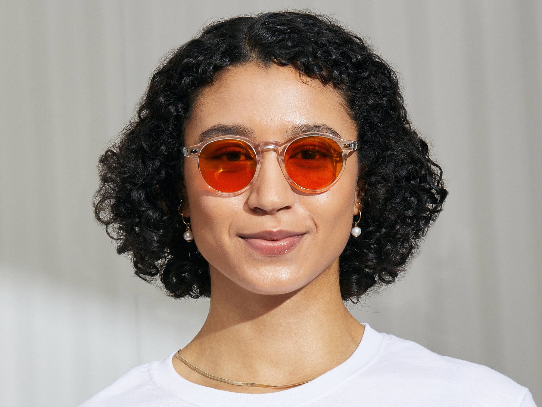 Model is wearing The MILTZEN in Crystal in size 49 with Woodstock Orange Tinted Lenses Model is wearing The MILTZEN in Crystal in size 49 with Woodstock Orange Tinted Lenses