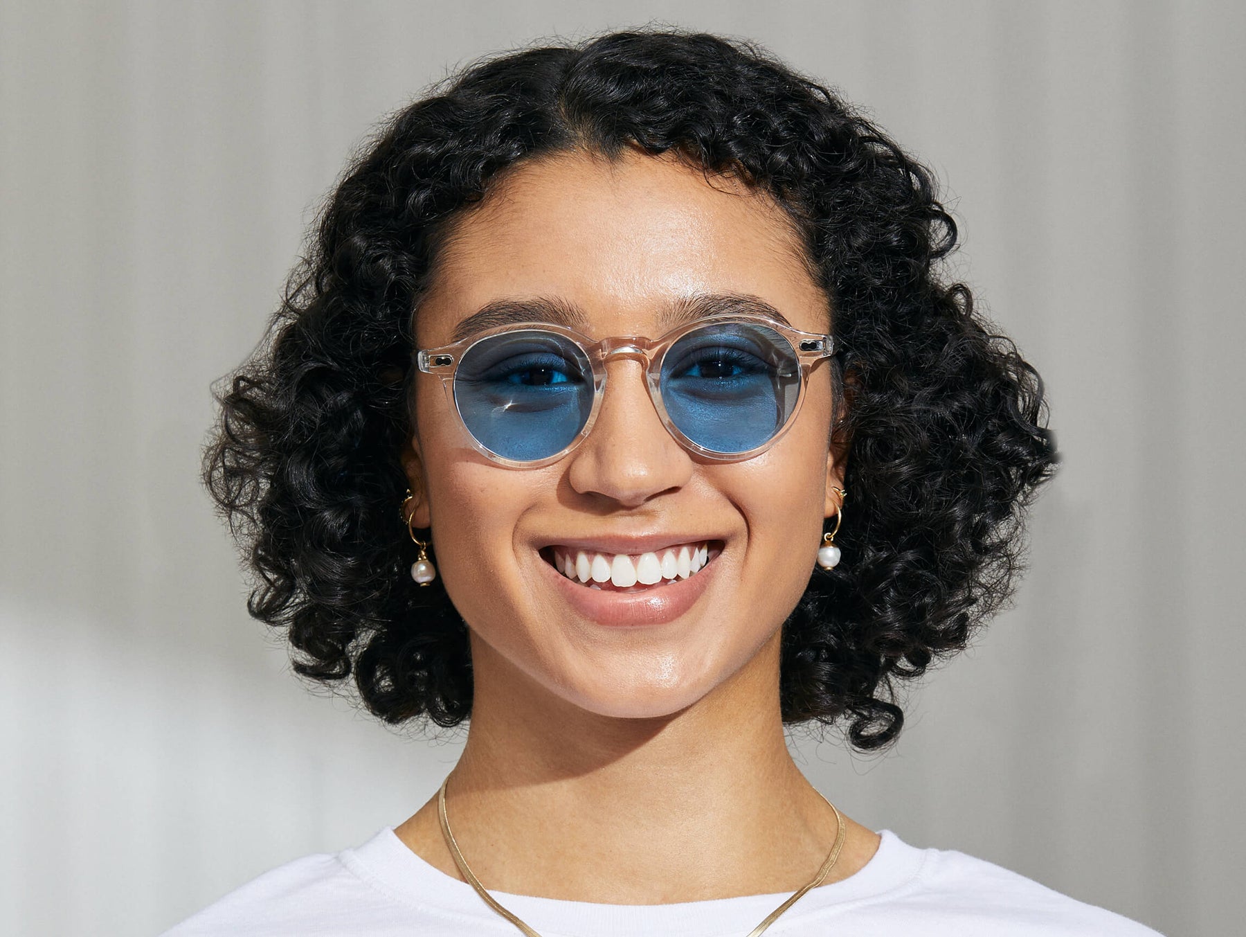 Model is wearing The MILTZEN in Crystal in size 49 with Celebrity Blue Tinted Lenses Model is wearing The MILTZEN in Crystal in size 49 with Celebrity Blue Tinted Lenses