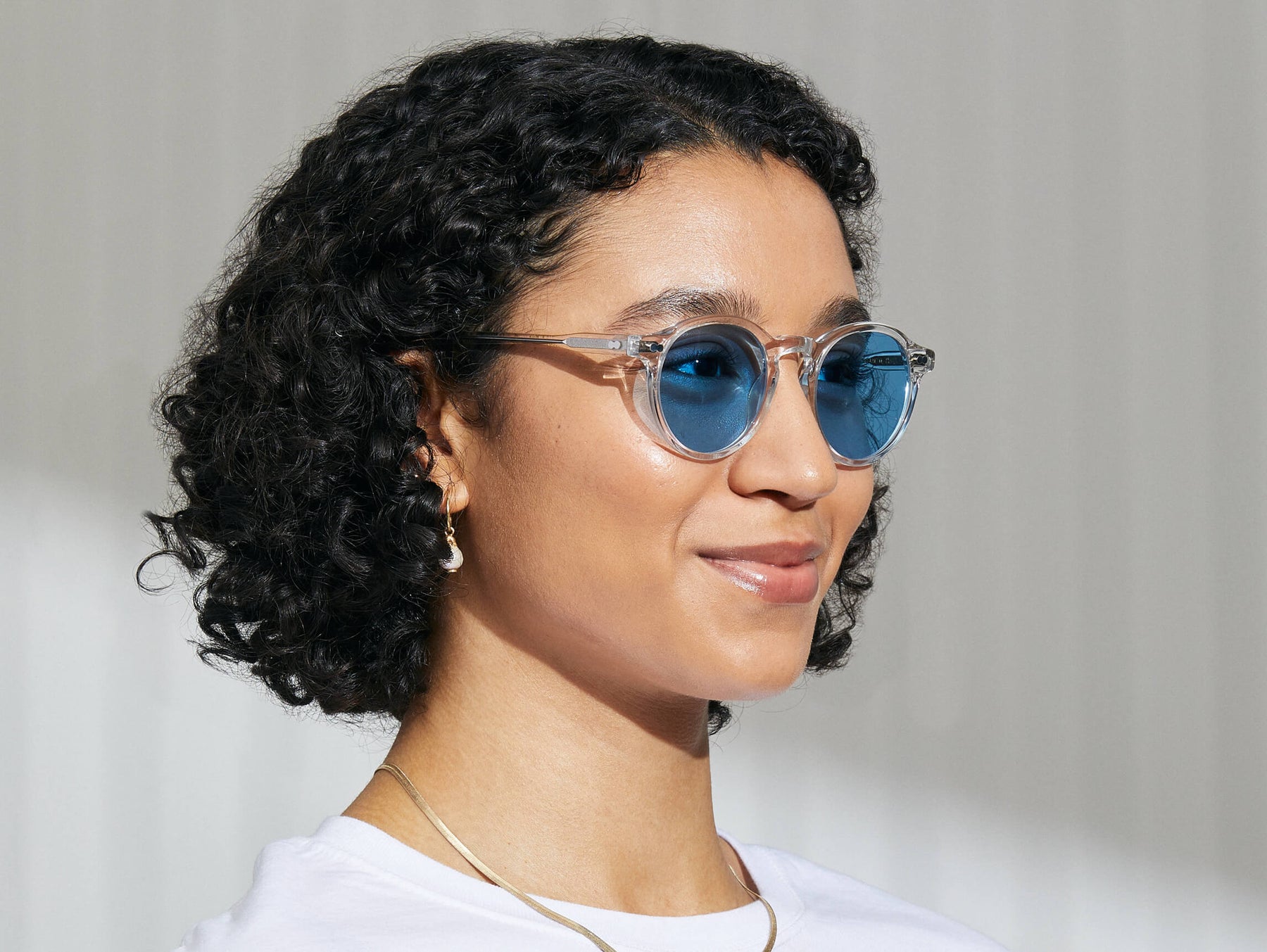 Model is wearing The MILTZEN in Crystal in size 49 with Celebrity Blue Tinted Lenses Model is wearing The MILTZEN in Crystal in size 49 with Celebrity Blue Tinted Lenses