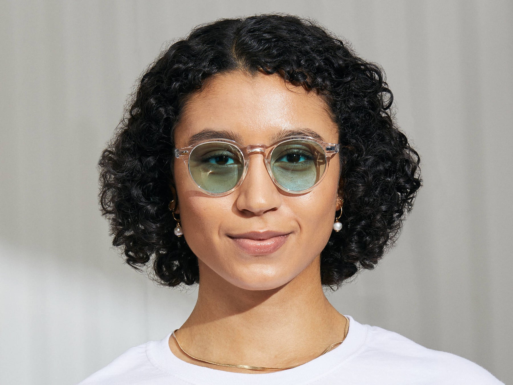 Model is wearing The MILTZEN in Crystal in size 49 with Turquoise Tinted Lenses Model is wearing The MILTZEN in Crystal in size 49 with Turquoise Tinted Lenses