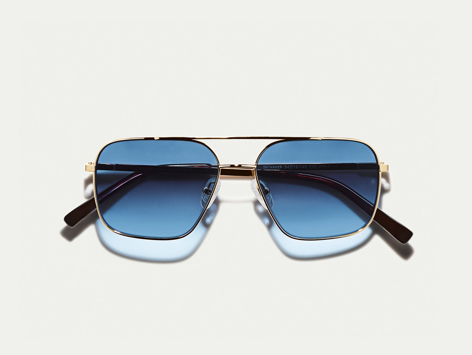 The SHTARKER in Gold with Denim Blue Tinted Lenses The SHTARKER in Gold with Denim Blue Tinted Lenses