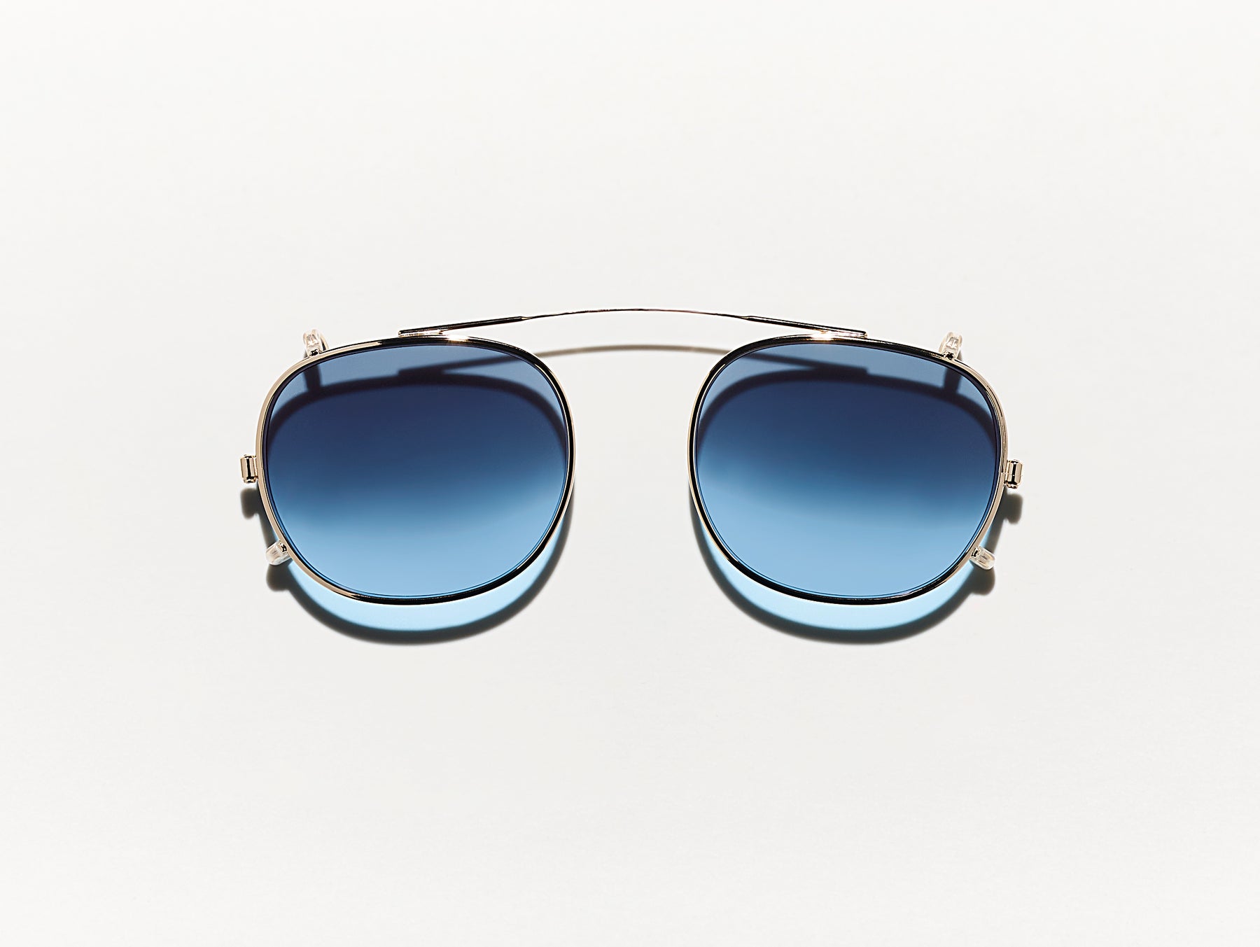 The CLIPTOSH in Gold with Denim Blue Tinted Lenses The CLIPTOSH in Gold with Denim Blue Tinted Lenses