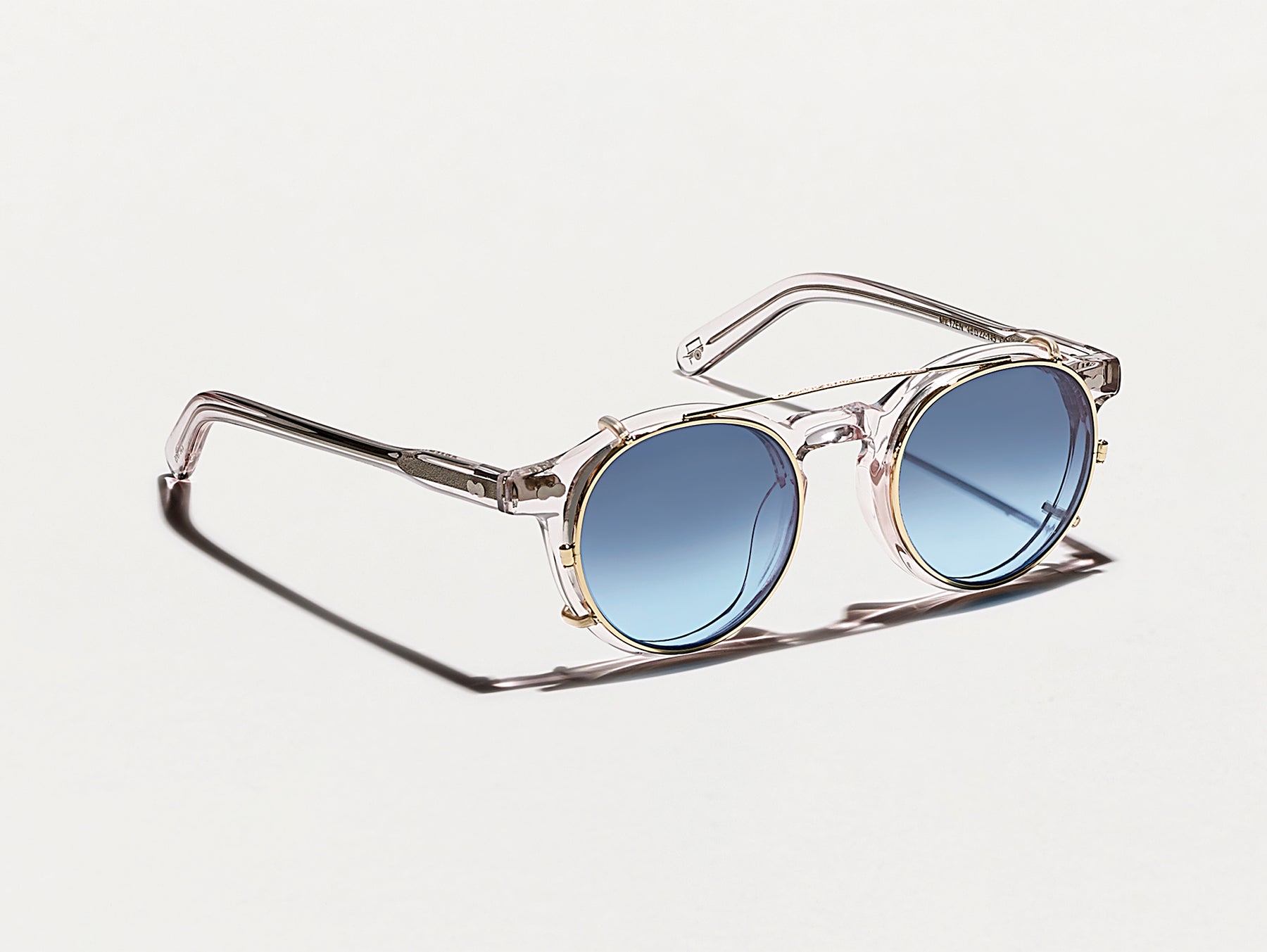 The CLIPZEN in Gold with Denim Blue Tinted Lenses The CLIPZEN in Gold with Denim Blue Tinted Lenses
