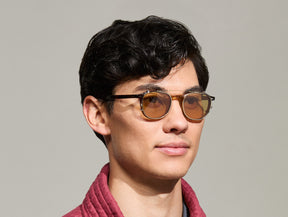 Model is wearing The ARTHUR CLIP in Gold in size 48 with Amber Tinted Lenses