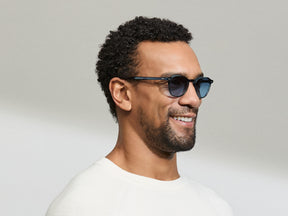 Model is wearing The ARTHUR in Ink in size 48 with Denim Blue Tinted Lenses