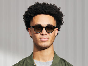 Model is wearing The BAITSIM SUN in Dark Green in size 48 with Forest Wood Tinted Lenses