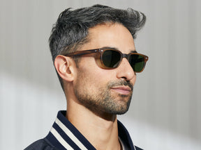 Model is wearing The BOYCHIK SUN in Matte Dark Blonde in size 49 with Calibar Green Glass Lenses