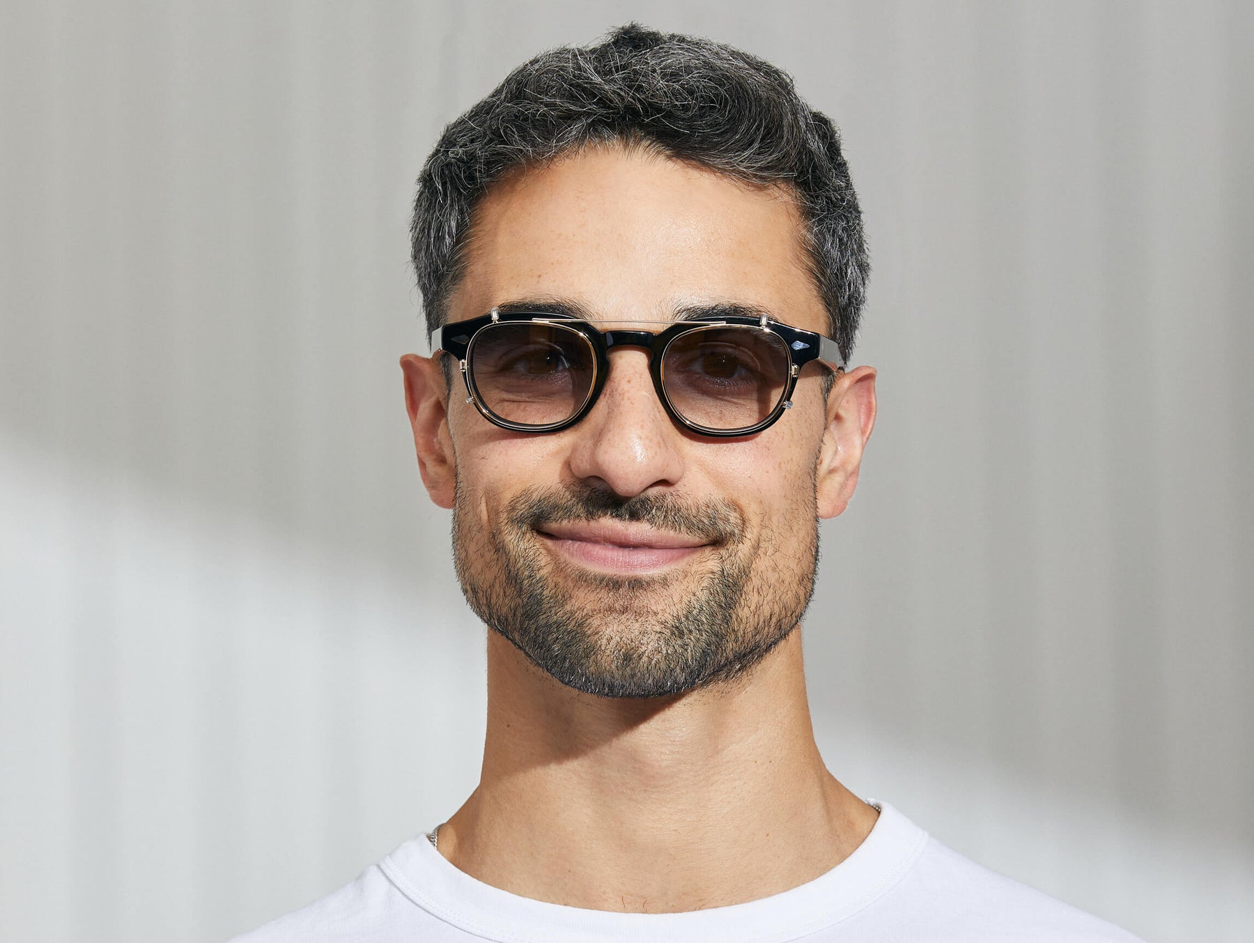 Model is wearing The CLIPTOSH in Gold in size 46 with American Grey Fade Tinted Lenses