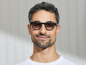 Model is wearing The CLIPTOSH in Gold in size 46 with American Grey Fade Tinted Lenses