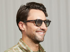 Model is wearing The DAHVEN CLIP in Gold in size 47 with Forest Wood Tinted Lenses