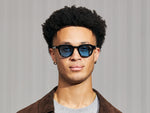Model is wearing The DAHVEN in Black in size 47 with Celebrity Blue Tinted Lenses