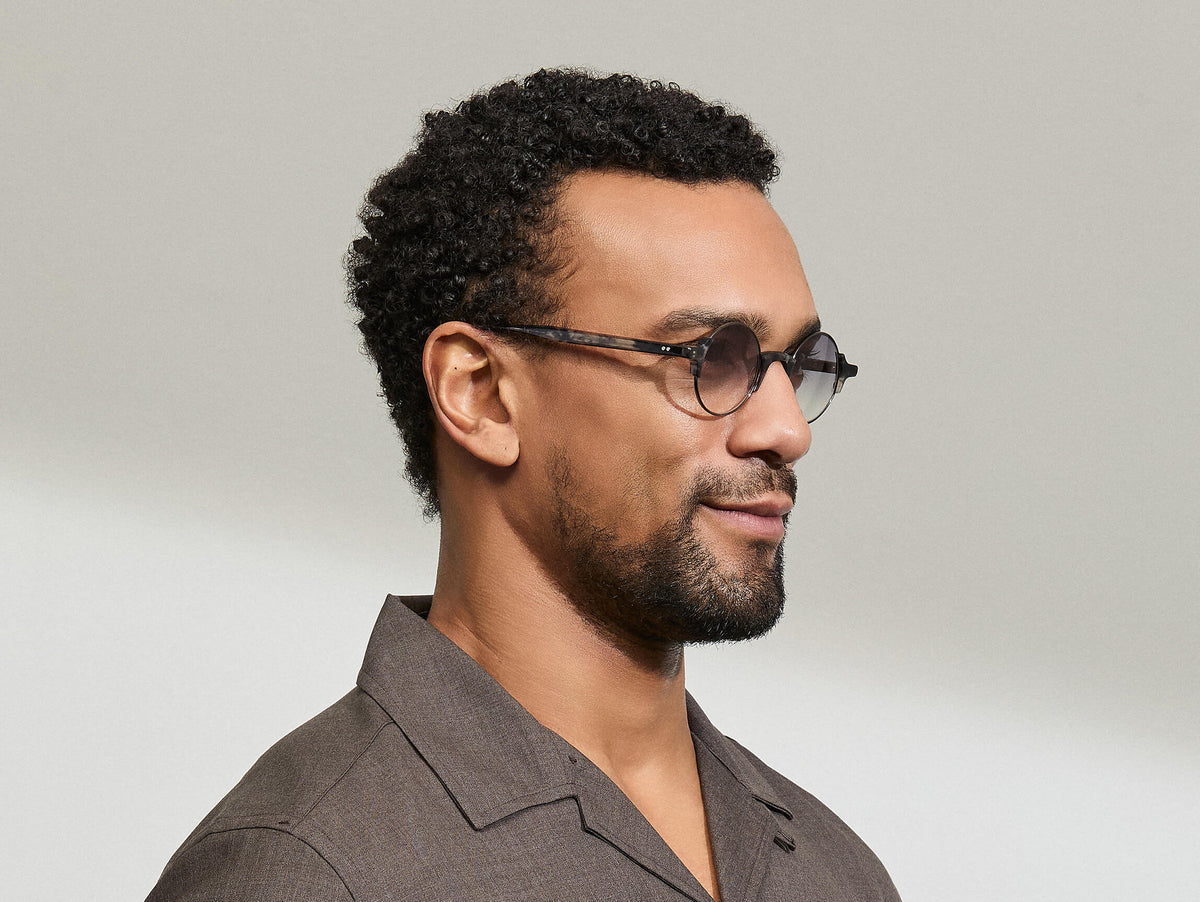 Model is wearing The DIBBIK SUN in size 45 in Smoke with American Grey Fade Tinted Lenses