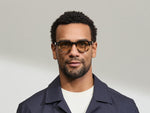 Model is wearing The DOLT in Grey-Brown Fade in size 46 with AMBER+ Lenses