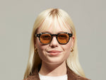 Model is wearing The DOLT CLIP in Gold in size 46 with Amber Tinted Lenses