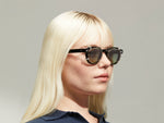 Model is wearing The DOLT CLIP in Gold in size 46 with Forest Wood Tinted Lenses