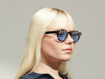 Model is wearing The DOLT CLIP in Gold in size 46 with Celebrity Blue Tinted Lenses