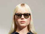Model is wearing The DOLT CLIP in Gold in size 46 with Forest Wood Tinted Lenses