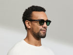 Model is wearing The DOLT in Black in size 46 with GREEN+ Lenses