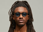 Model is wearing The DOLT SUN Limited Edition in size 46 in Bark with Blue Tinted Lenses