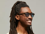 Model is wearing The DOLT SUN Limited Edition in size 46 in Bark with Blue Tinted Lenses