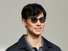 Model is wearing The FEVEL SUN in Dark Green in size 49 with Forest Wood Tinted Lenses