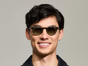 Model is wearing The FRANKIE CLIP in Gold in size 48 with Forest Wood Tinted Lenses