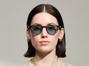Model is wearing The FRANKIE SUN in Ink in size 51 with Mineral Blue Tinted Lenses