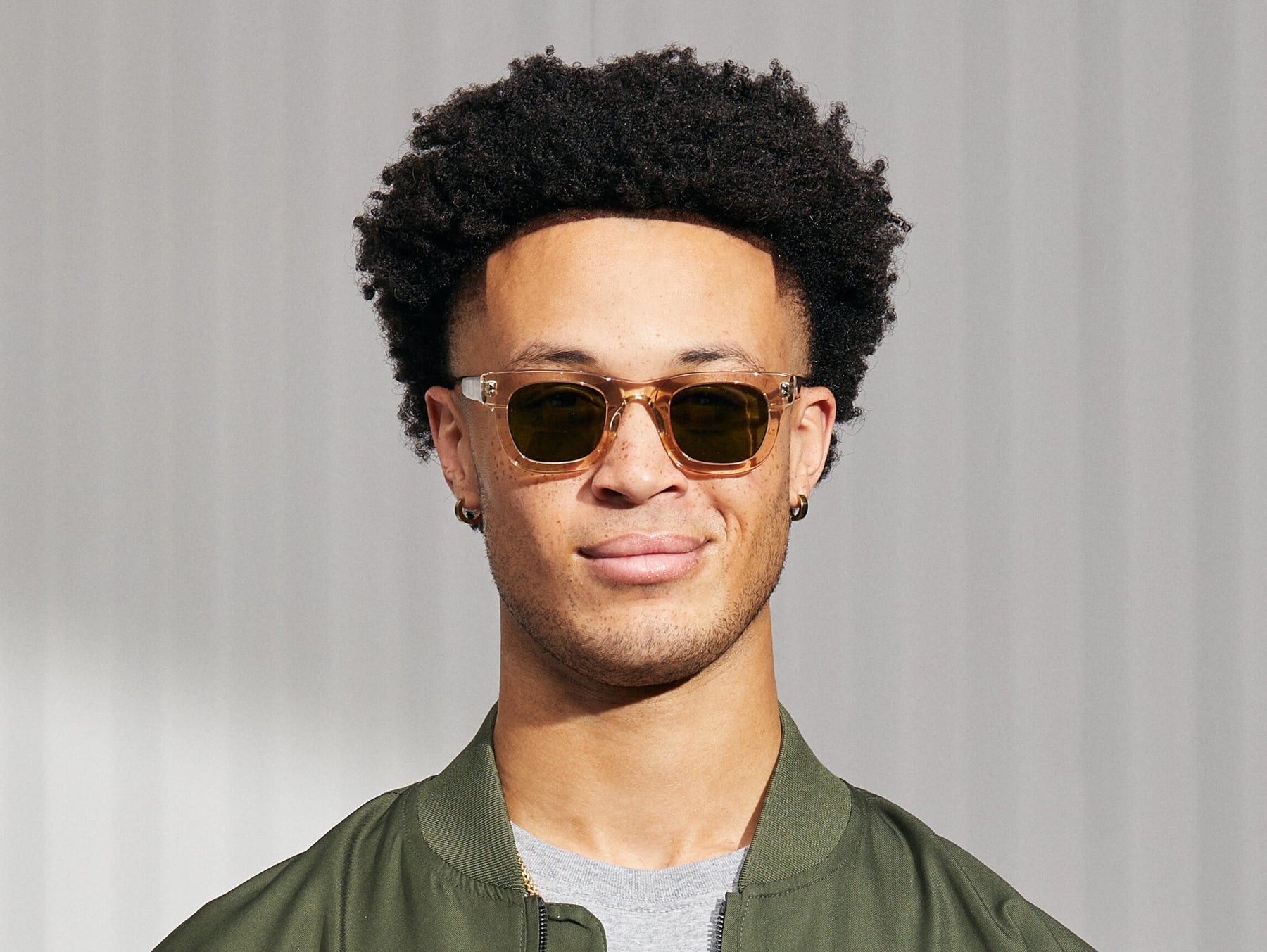 Model is wearing the FRITZ SUN in Cinnamon/Flesh in size 44 with Calibar Green Glass Lenses