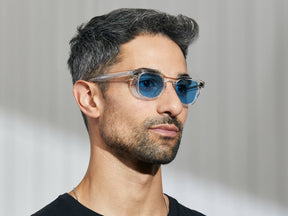 Model is wearing The GELT in Crystal in size 46 with Celebrity Blue Tinted Lenses