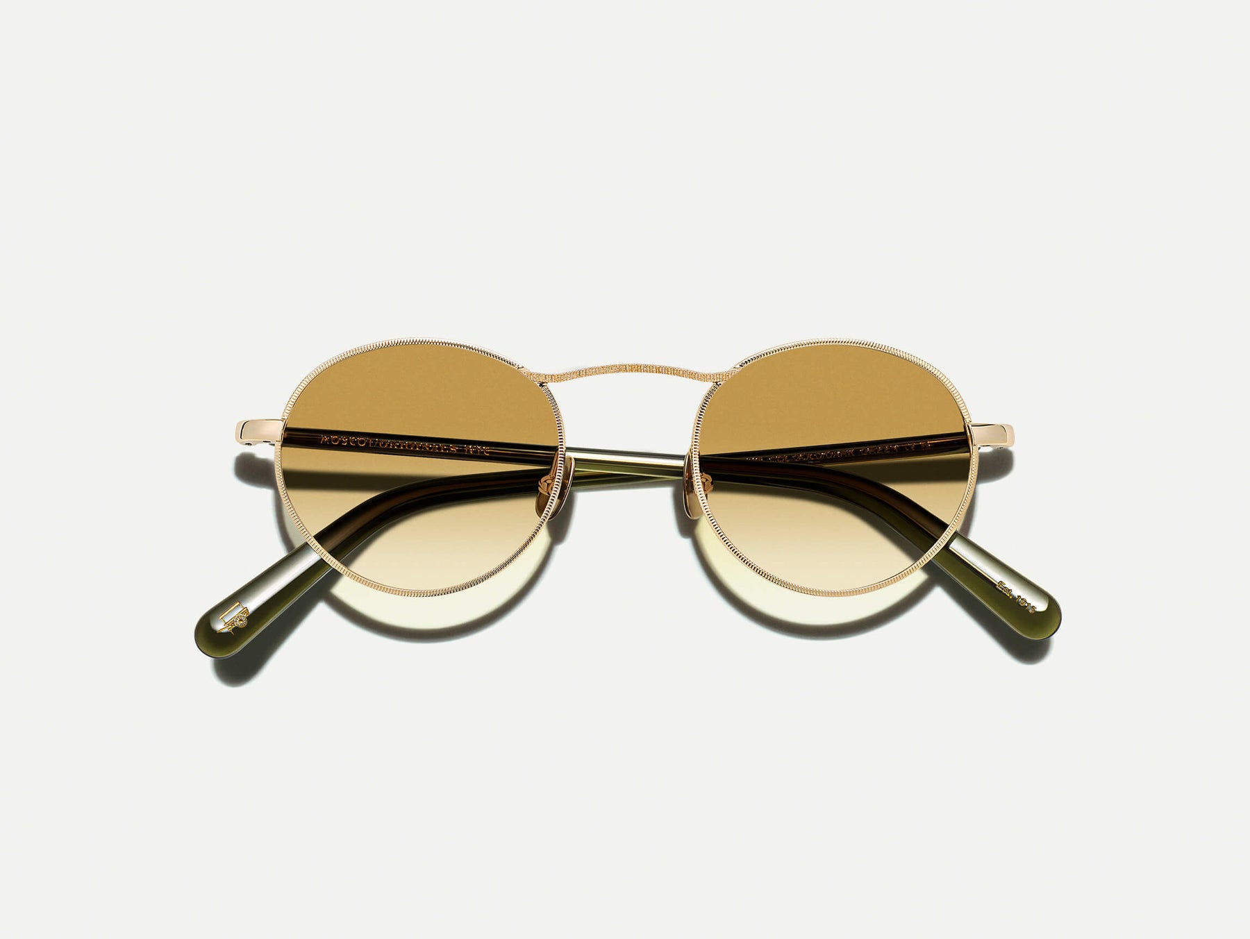 The KANAKA SUN in Gold/Dark Green with Chestnut Fade Tinted Lenses