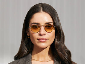 Model is wearing The KANAKA SUN in Gold/Dark Green in size 49 with Chestnut Fade Tinted Lenses