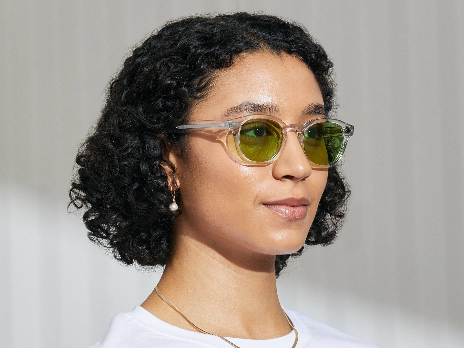 Model is wearing The LEMTOSH in Crystal in size 49 with Garnet Green Tinted Lenses