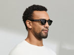 Model is wearing The LEMTOSH SUN in size 46 in Black with G-15 Glass Lenses
