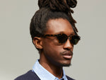 Model is wearing The LEMTOSH SUN with Metal Nose Pads in Tortoise in size 46 with G-15 Glass Lenses