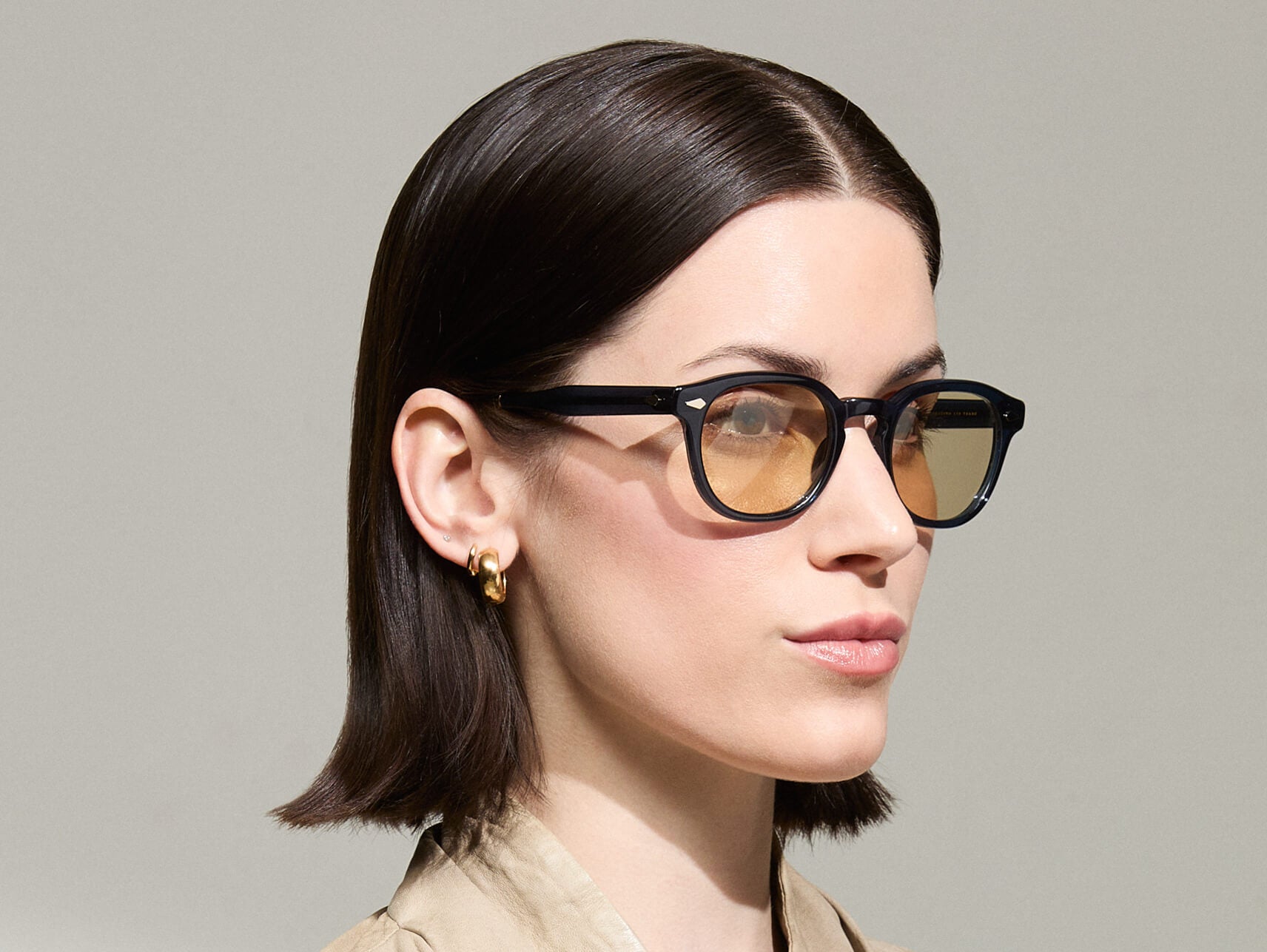 Model is wearing The LEMTOSH-TT 110 SUN in size 49 in Navy/Gold with BROWN+ Lenses