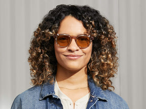 Model is wearing The MAYDELA CLIP in Gold in size 49 with Amber Tinted Lenses