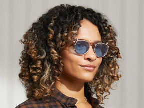 Model is wearing The MAYDELA CLIP in Gold in size 49 with Celebrity Blue Tinted Lenses