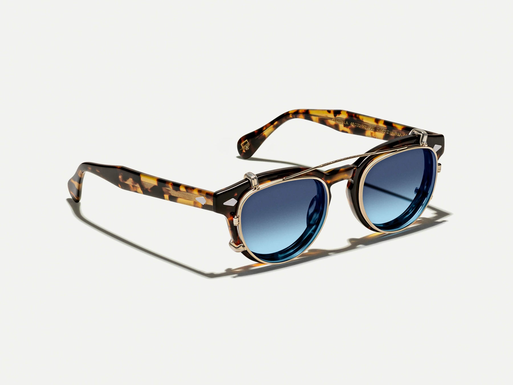 The MAYDELA CLIP in Gold with Denim Blue Tinted Lenses