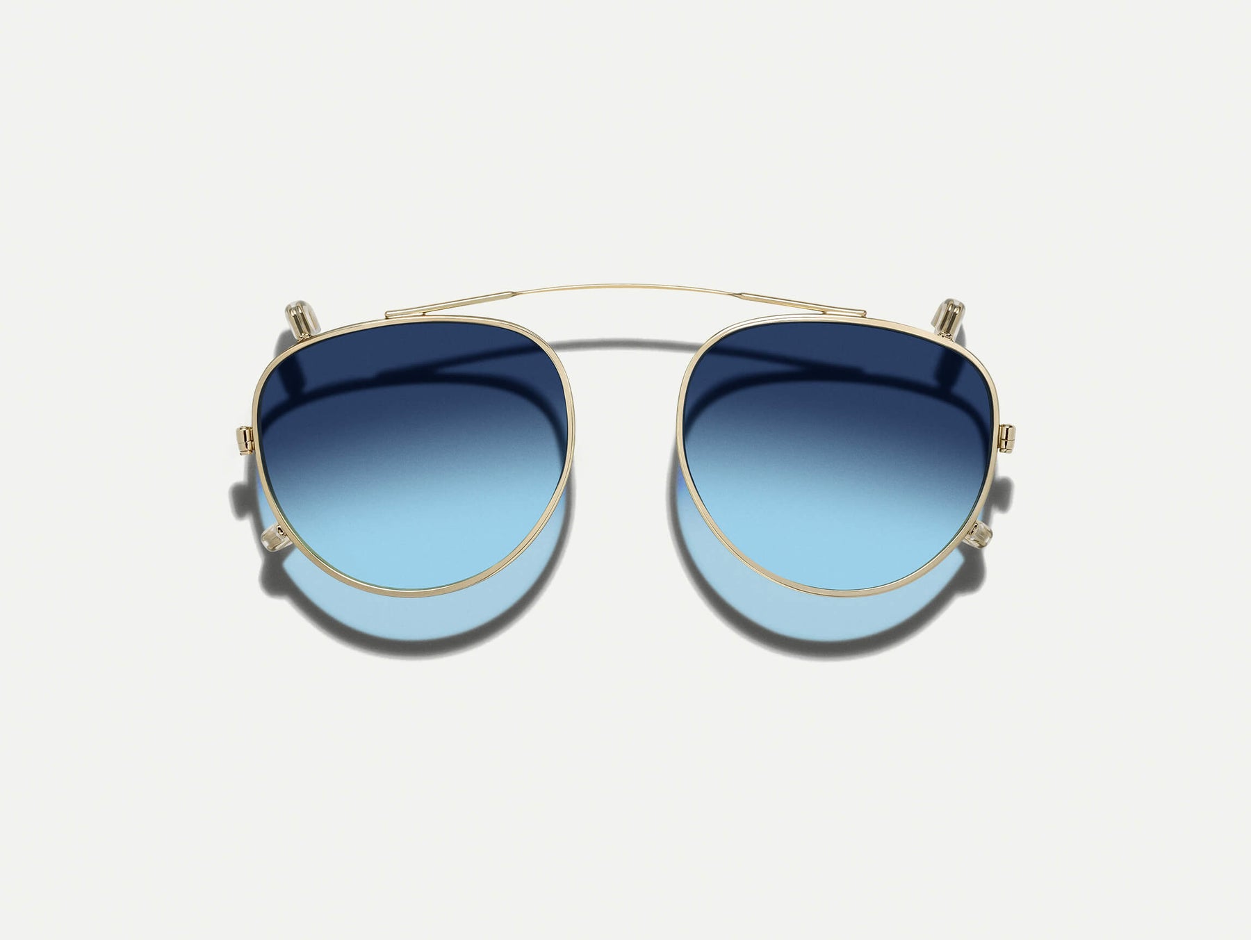 The MAYDELA CLIP in Gold with Denim Blue Tinted Lenses