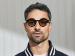 Model is wearing The MAYDELA SUN in Black in size 46 with Amber Tinted Lenses