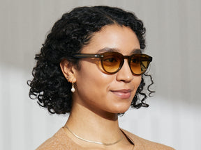 Model is wearing The MAYDELA SUN in Olive Brown in size 49 with Chestnut Fade Tinted Lenses