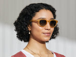 Model is wearing The MAYDELA SUN in Goldenrod in size 49 with Forest Wood Tinted Lenses