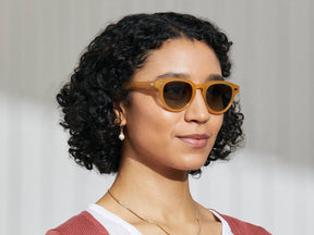Model is wearing The MAYDELA SUN in Goldenrod in size 49 with Forest Wood Tinted Lenses
