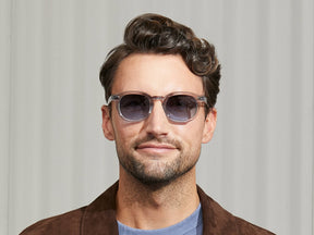 Model is wearing The MEKLER SUN in Light Grey in size 49 with Denim Blue Tinted Lenses