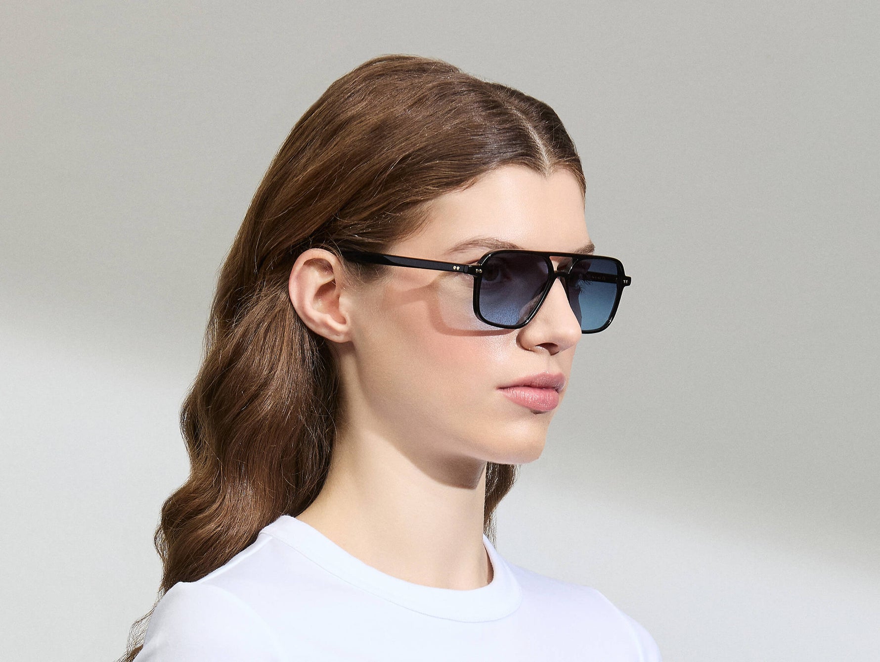 Model is wearing The MINYAN SUN in size 54 in Black with Denim Blue Tinted Lenses