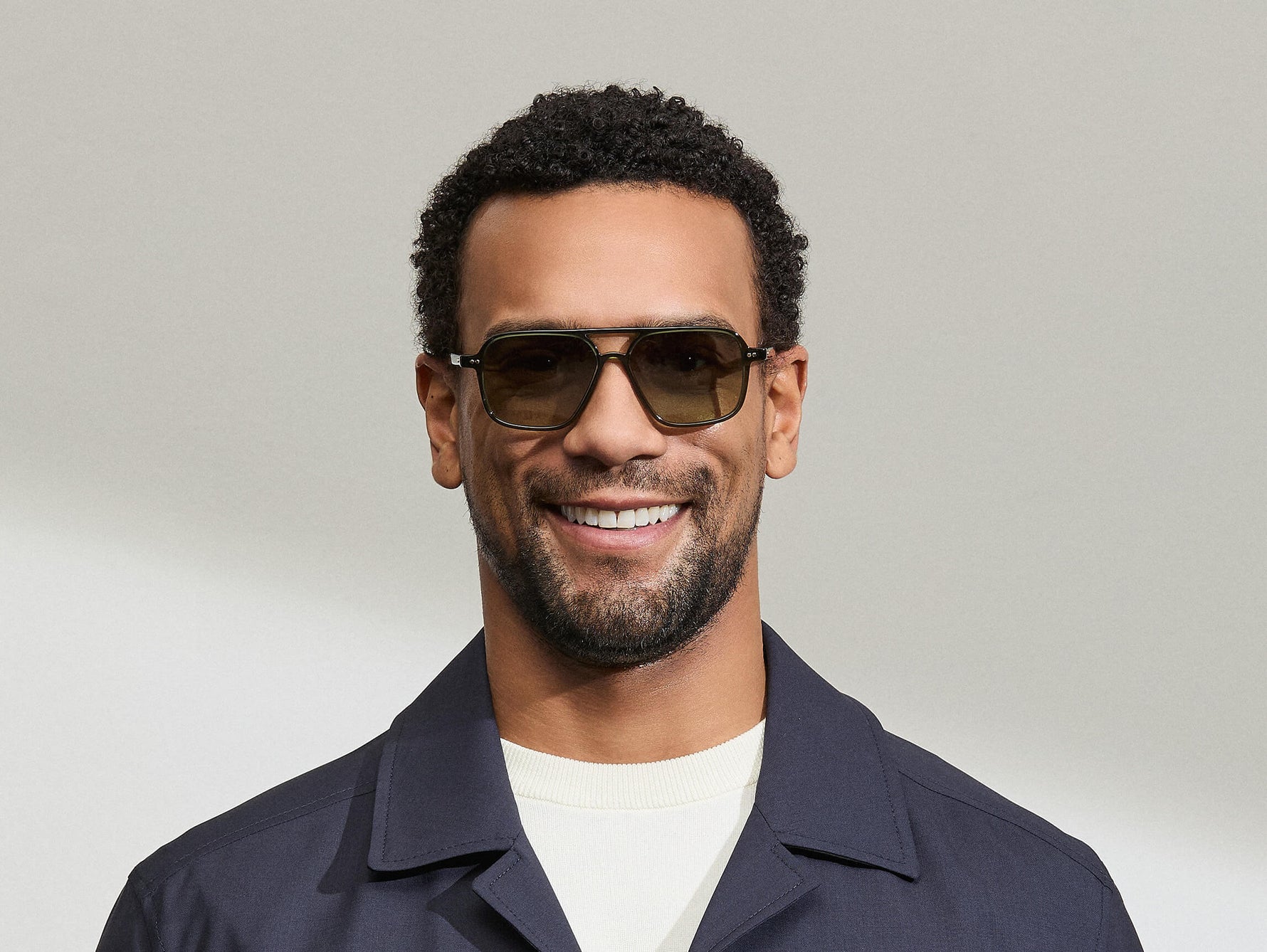 Model is wearing The MINYAN SUN in size 54 in Dark Green with Forest Wood Tinted Lenses